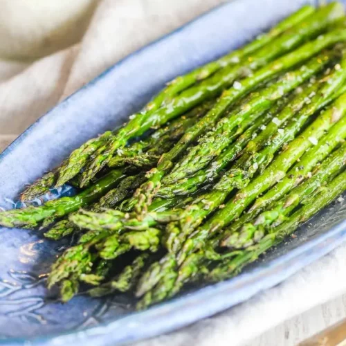 overhead of asparagus on a blue serving dish.