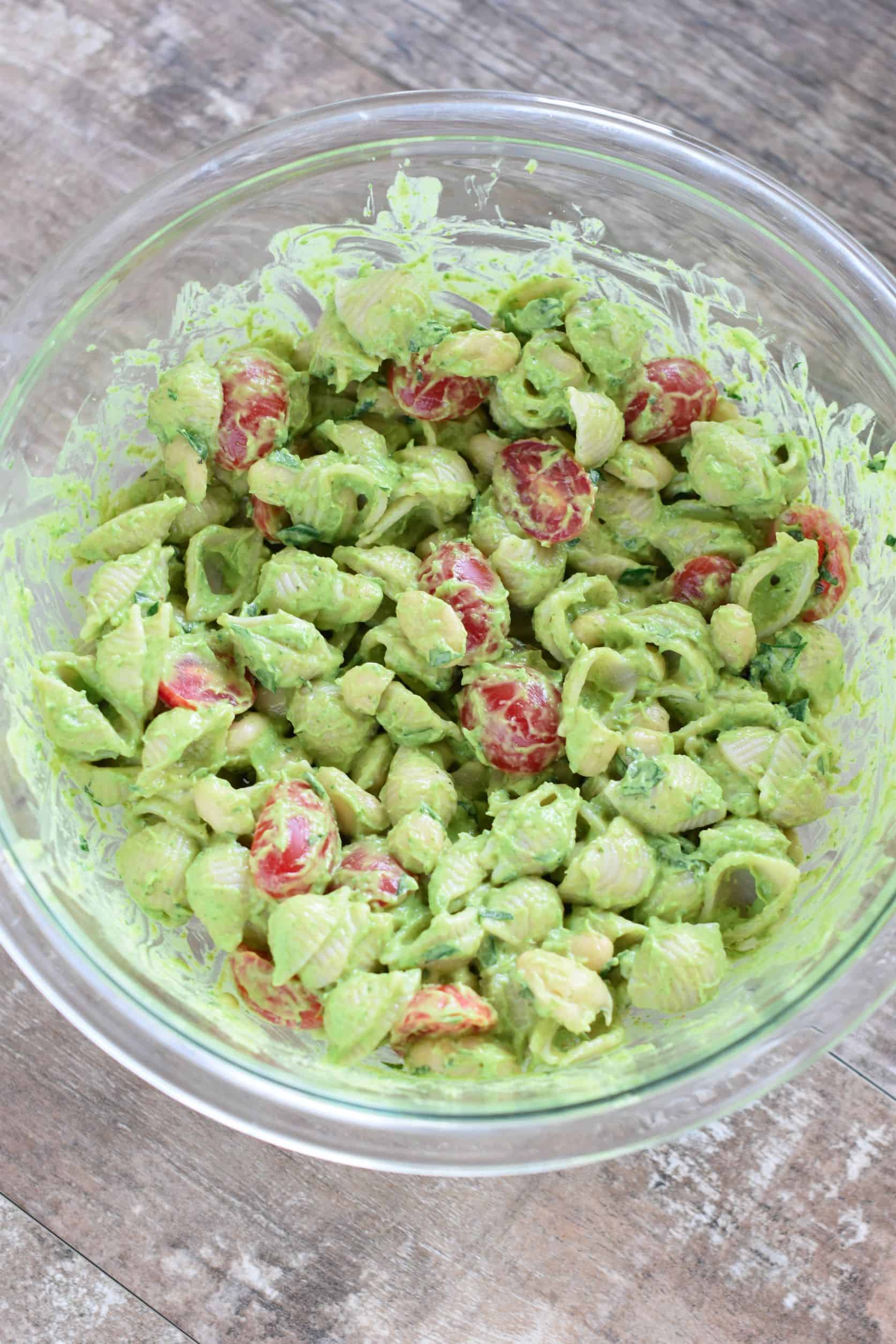 avocado folded into the pasta in the mixing bowl.