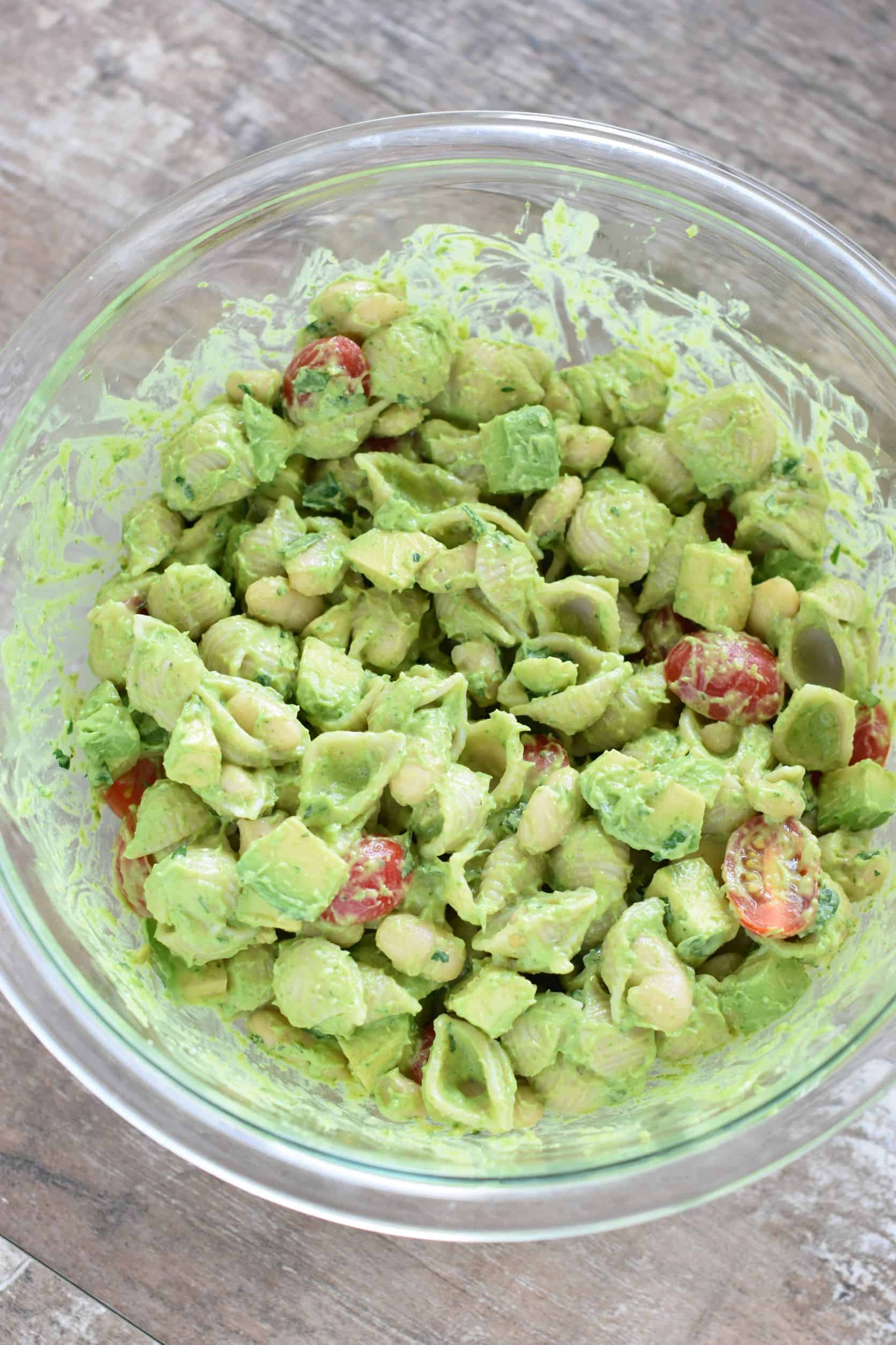 avocado folded into the pasta in the mixing bowl.