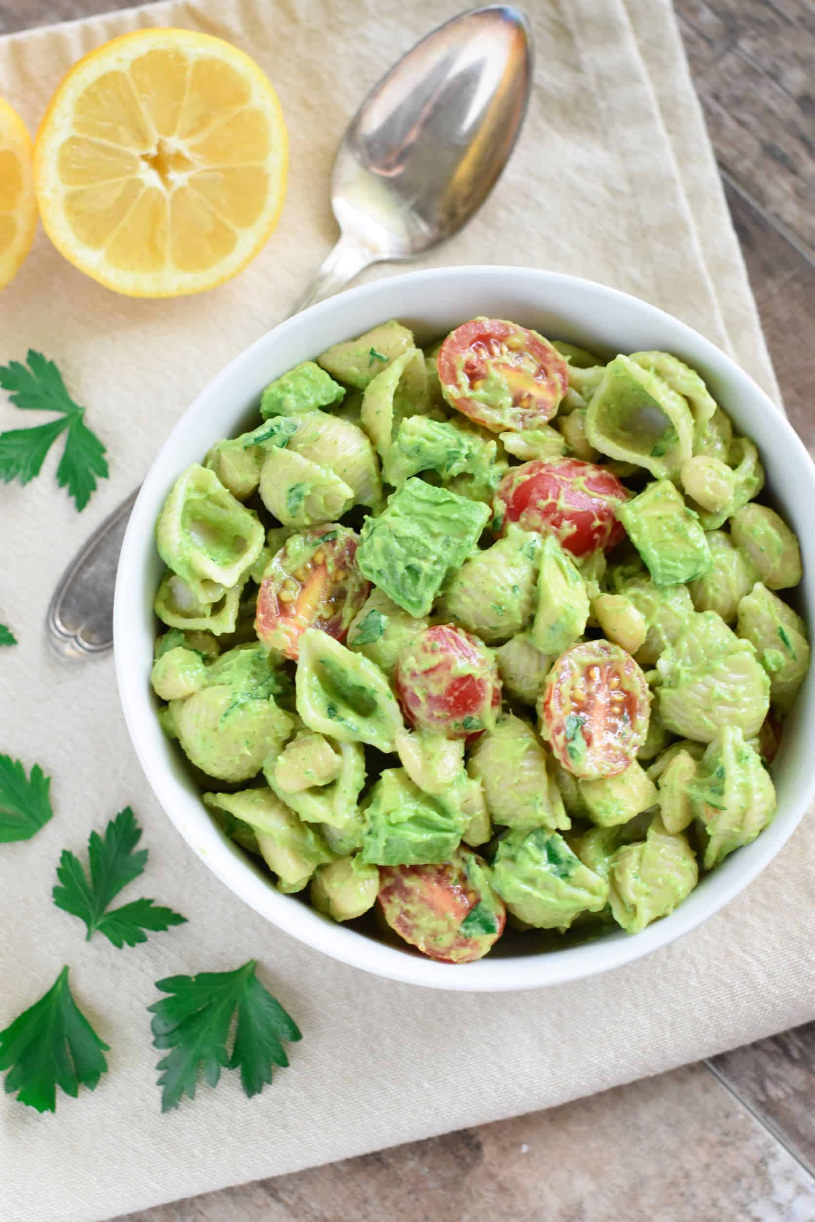 overhead of pasta salad with garnish on a napkin and a spoon to the left.