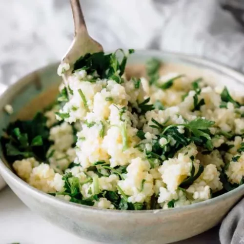 millet in a white bowl with a fork in it.