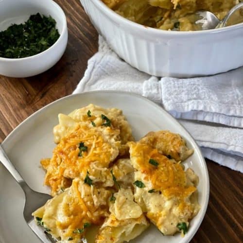 serving of vegan scalloped potatoes on a white plate with a fork.