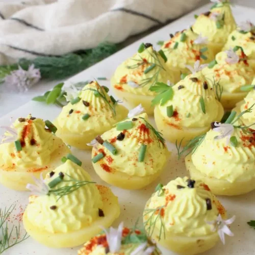 vegan deviled potatoes on a white serving dish.