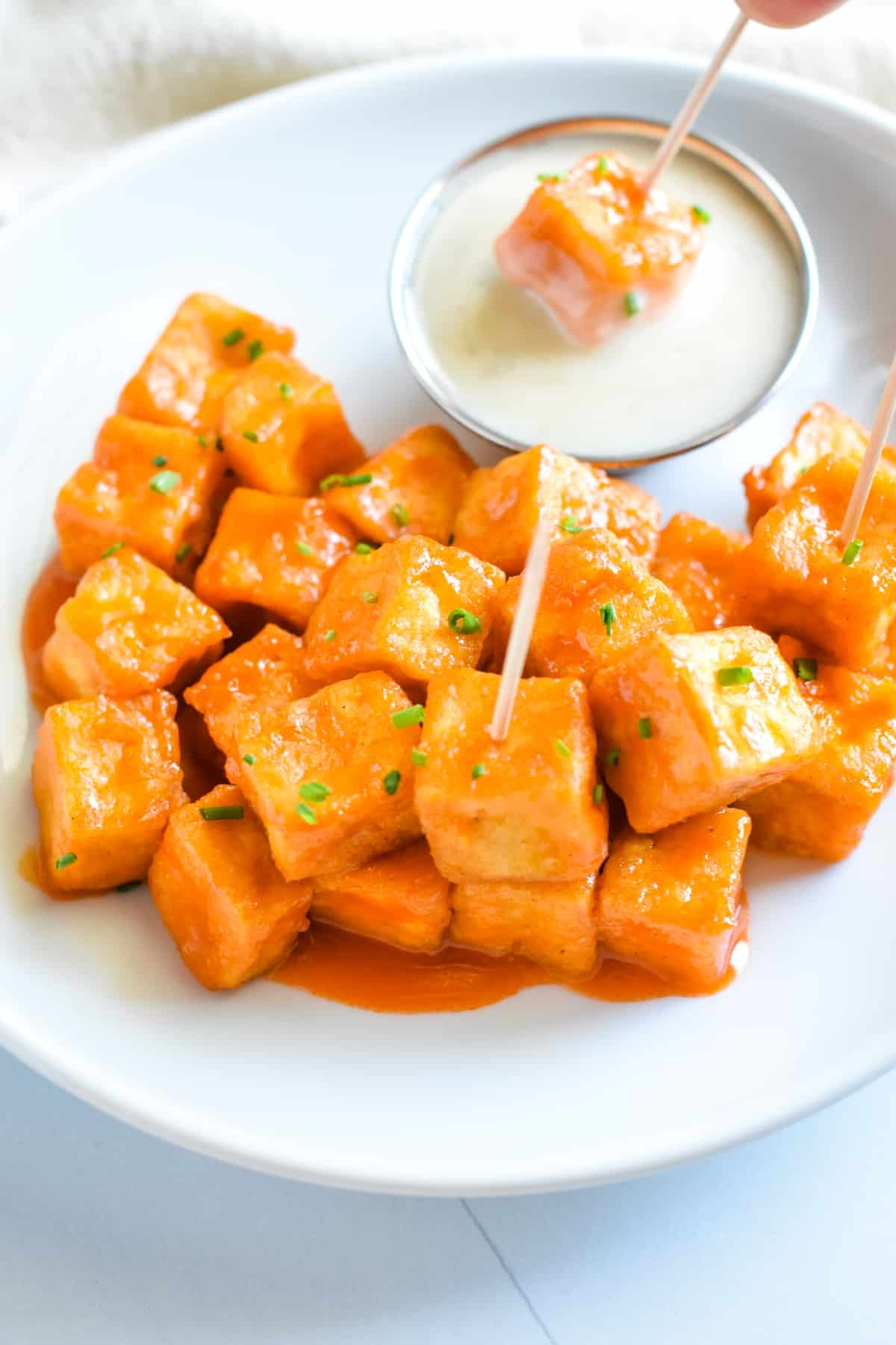 Air Fryer Buffalo Tofu with toothpicks on a plate.