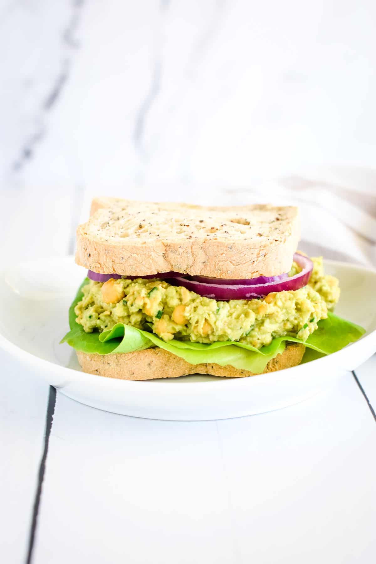 Whole Chickpea Avocado sandwich on a plate.