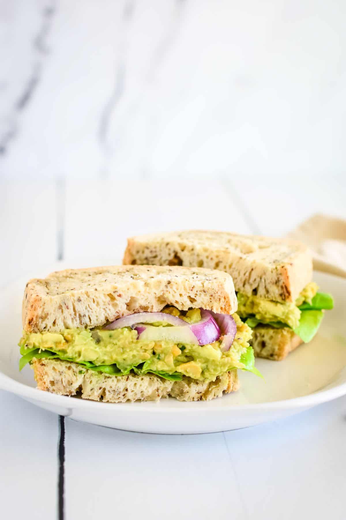 Chickpea sandwich on a plate cut in two.