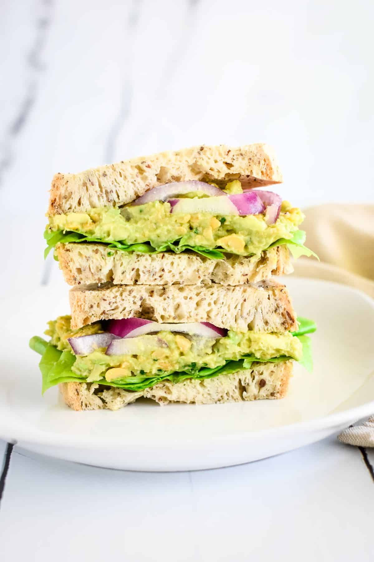 Two pieces of sandwich stacked on top of each other on a plate.