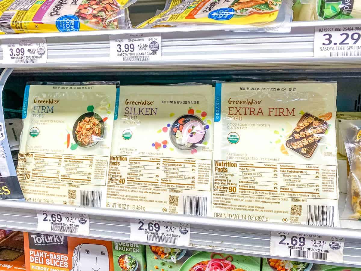 Packages of tofu on supermarket shelves.