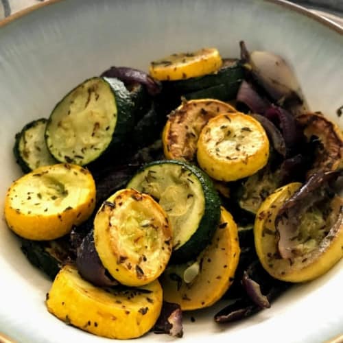 Roasted summer squash and zucchini in a dish.