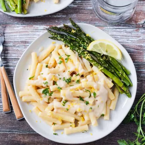 Vegan white sauce over pasta on a plate.