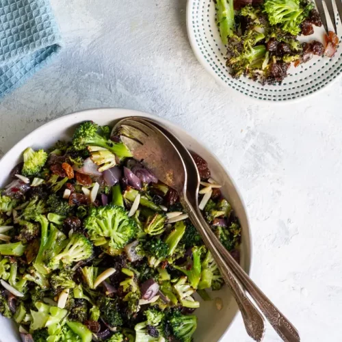 broccoli raisin salad in a bowl with spoons.