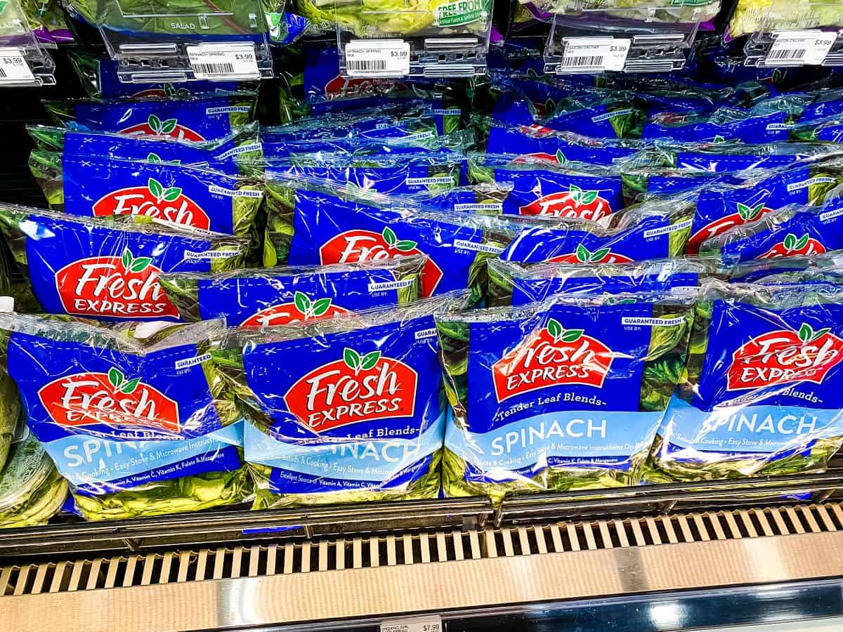 Bags of spinach displayed in a supermarket.