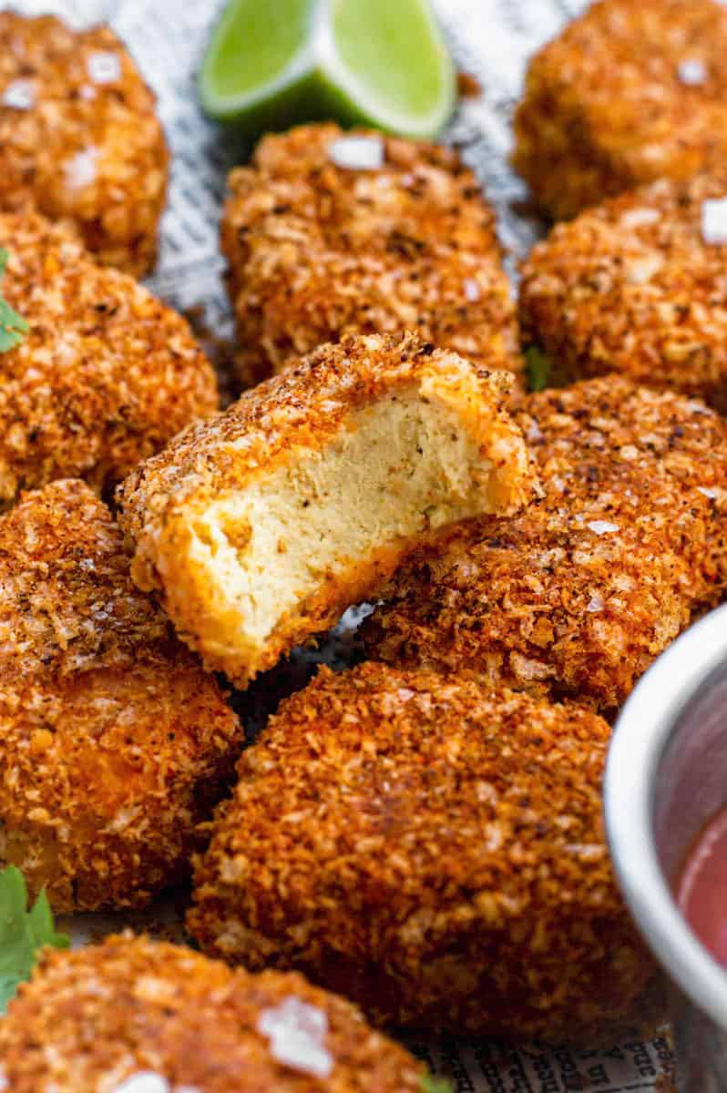 A tofu nugget with a bite taken out of it.