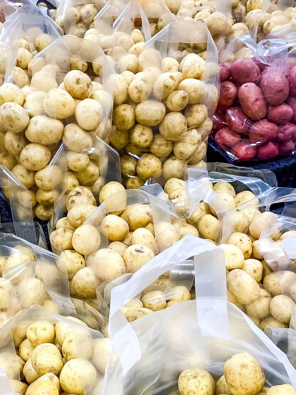 Bags of yellow spuds at supermarket.