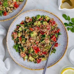 Copycat Costco Quinoa Salad served in a blue bowl with a fork placed on the right side of the bowl.