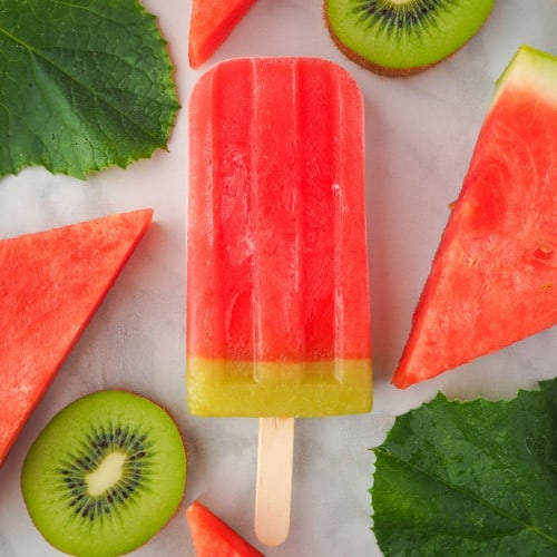 Watermelon ice lollie on marble surface.