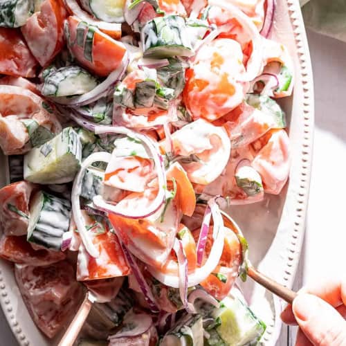 Creamy Tomato Cucumber Salad being served on a dish.