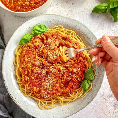 Vegan spaghetti in a bowl with a fork.