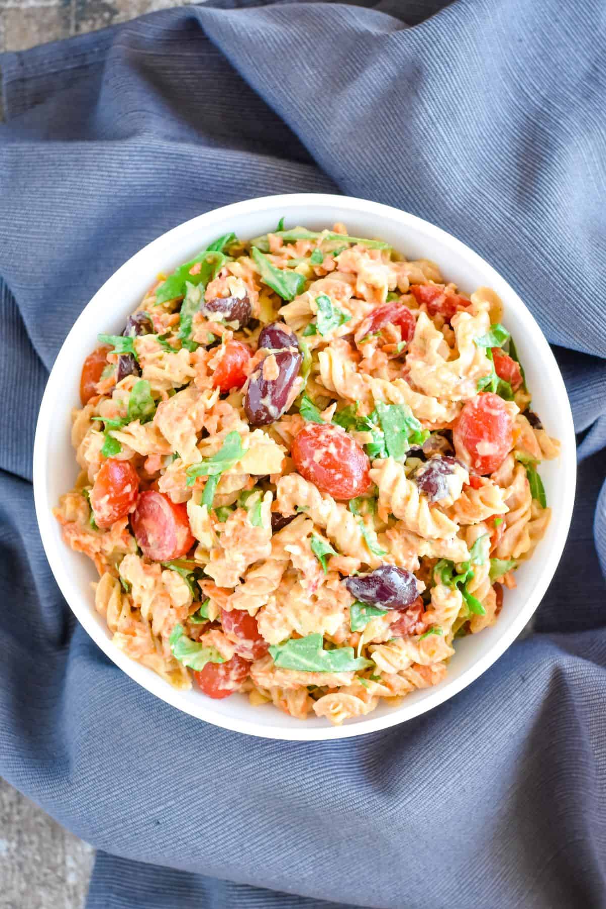 overhead of pasta salad in a bowl on a kitchen towel.