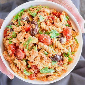 close-up overhead of hands holding pasta salad up.