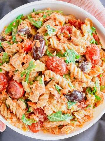 close-up overhead of hands holding pasta salad up.