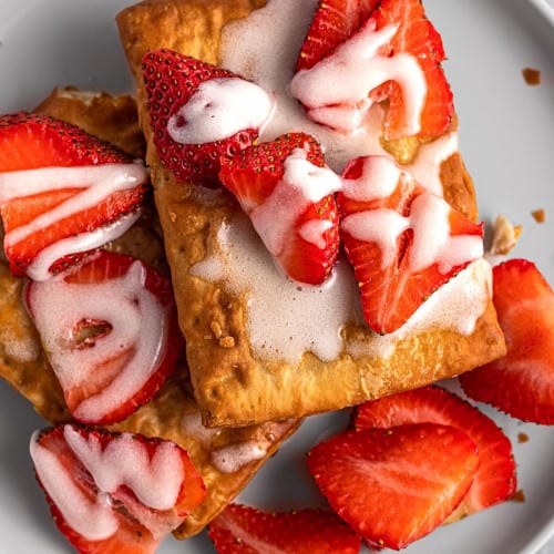 Air fryer toaster strudel with strawberries on a plate.