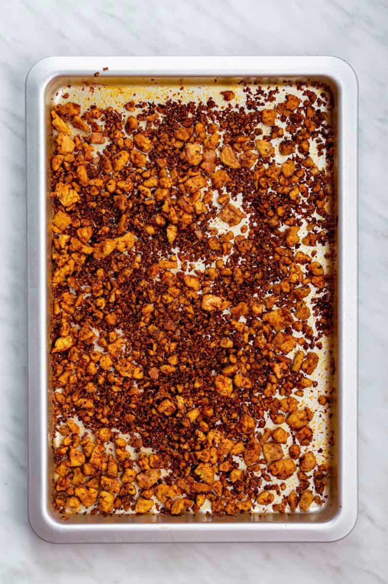 Tofu ground beef crumbles on a stainless steel baking sheet.