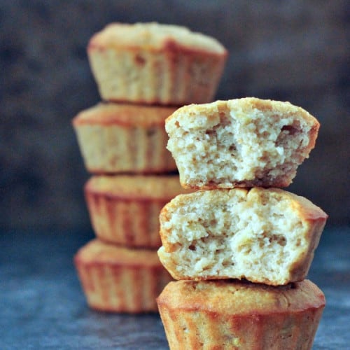 stack of 3 peanut butter banana muffins with top two having been bitten and another stack in the background.