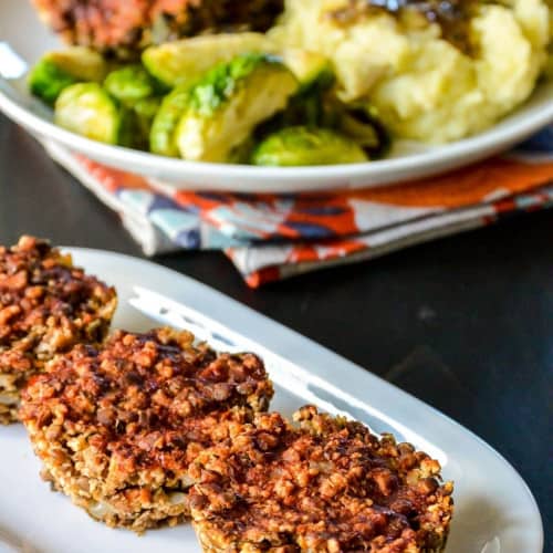 three lentil meatloaf muffins on a white serving dish.