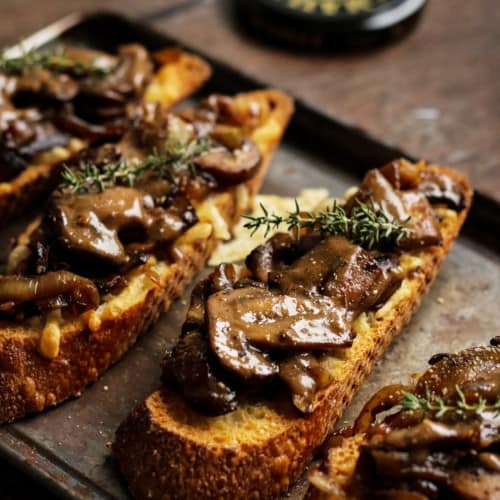 slices of mushroom crostini on a baking sheet.