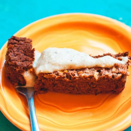 slice of vegan meatloaf with cashew gravy on a plate with a fork.