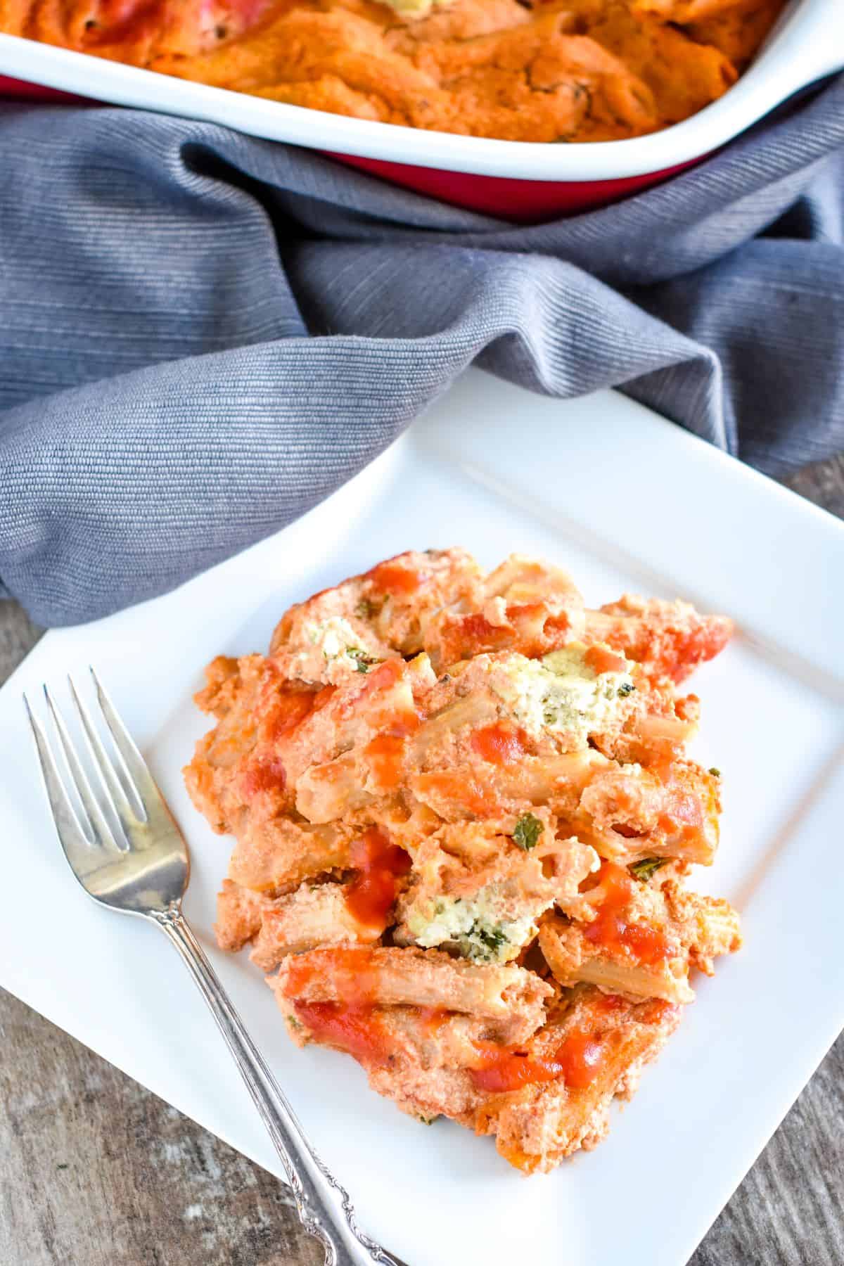 overhead of vegan baked ziti on a white plate with fork on the left side of the plate.