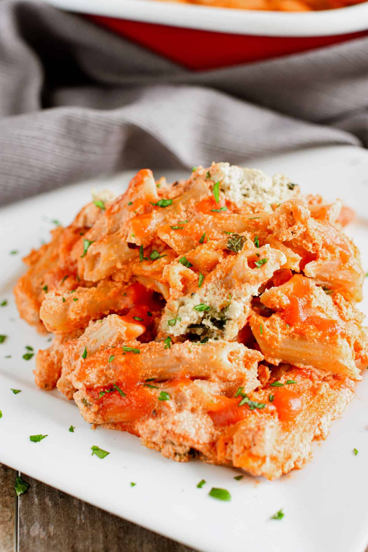 serving of ziti on a white plate with parsley garnish.