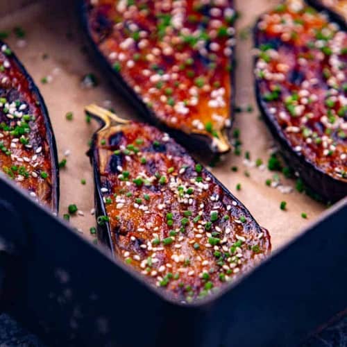 miso eggplant on parchment paper in a deep baking dish.