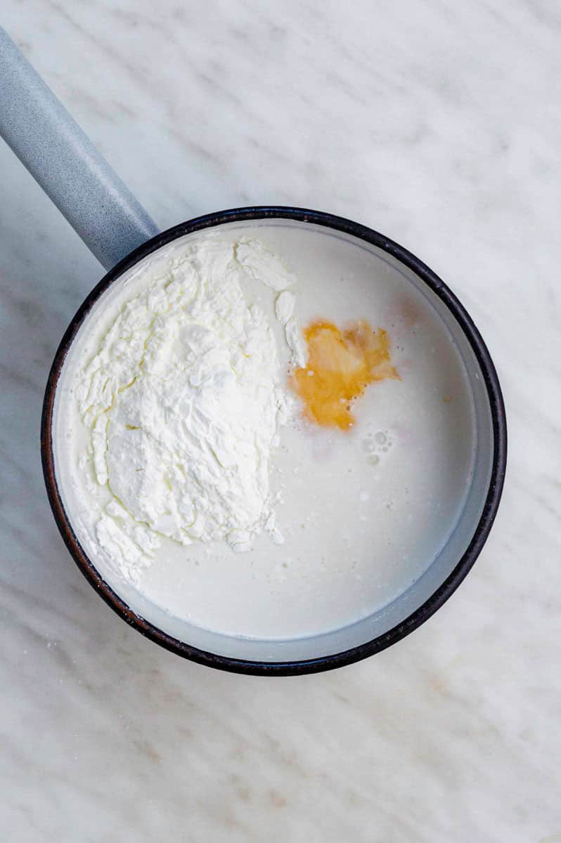 Ingredients for vegan custard added to a small saucepan.