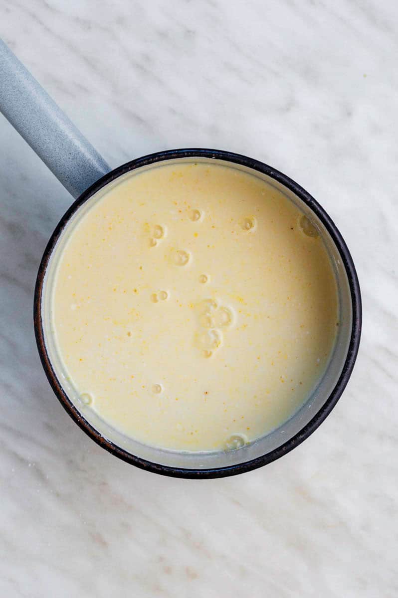 Vegan vanilla custard in a saucepan before cooking it on the stovetop.