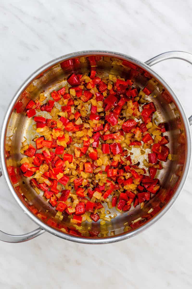 Sauteing vegetables in a stainless-steel pot.