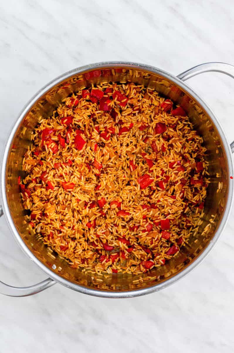 Toasting rice and spices in a stainless-steel pot.