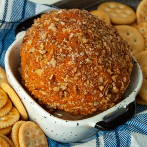 Cheese ball with crackers in a small dish.