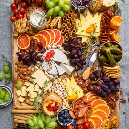 Vegan charcuterie board with fresh fruit, vegetables, crackers and dips.