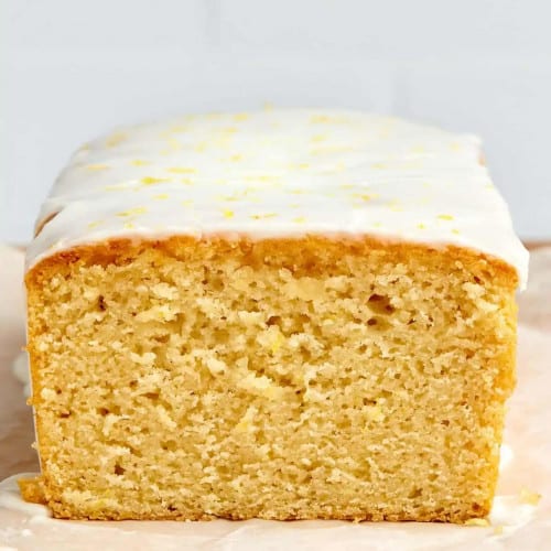 Loaf cake on the counter with a slice missing to show the texture of the texture of the cake.