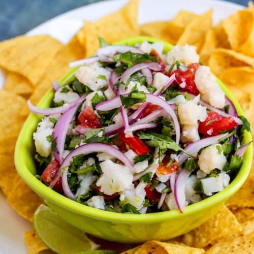 Bowl of cauliflower ceviche surrounded by tortilla chips.