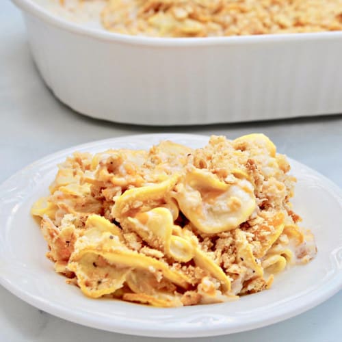 A plate of yellow squash casserole served up on the table.