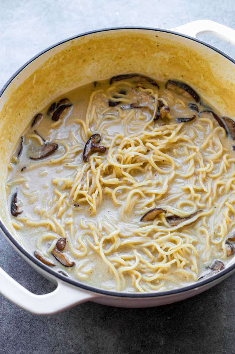 Vegan ramen with mushrooms in a white Dutch oven.