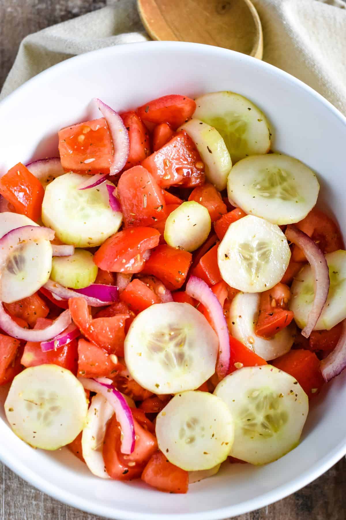 close-up overhead of salad in white bowl with spoon partially in view behind it.