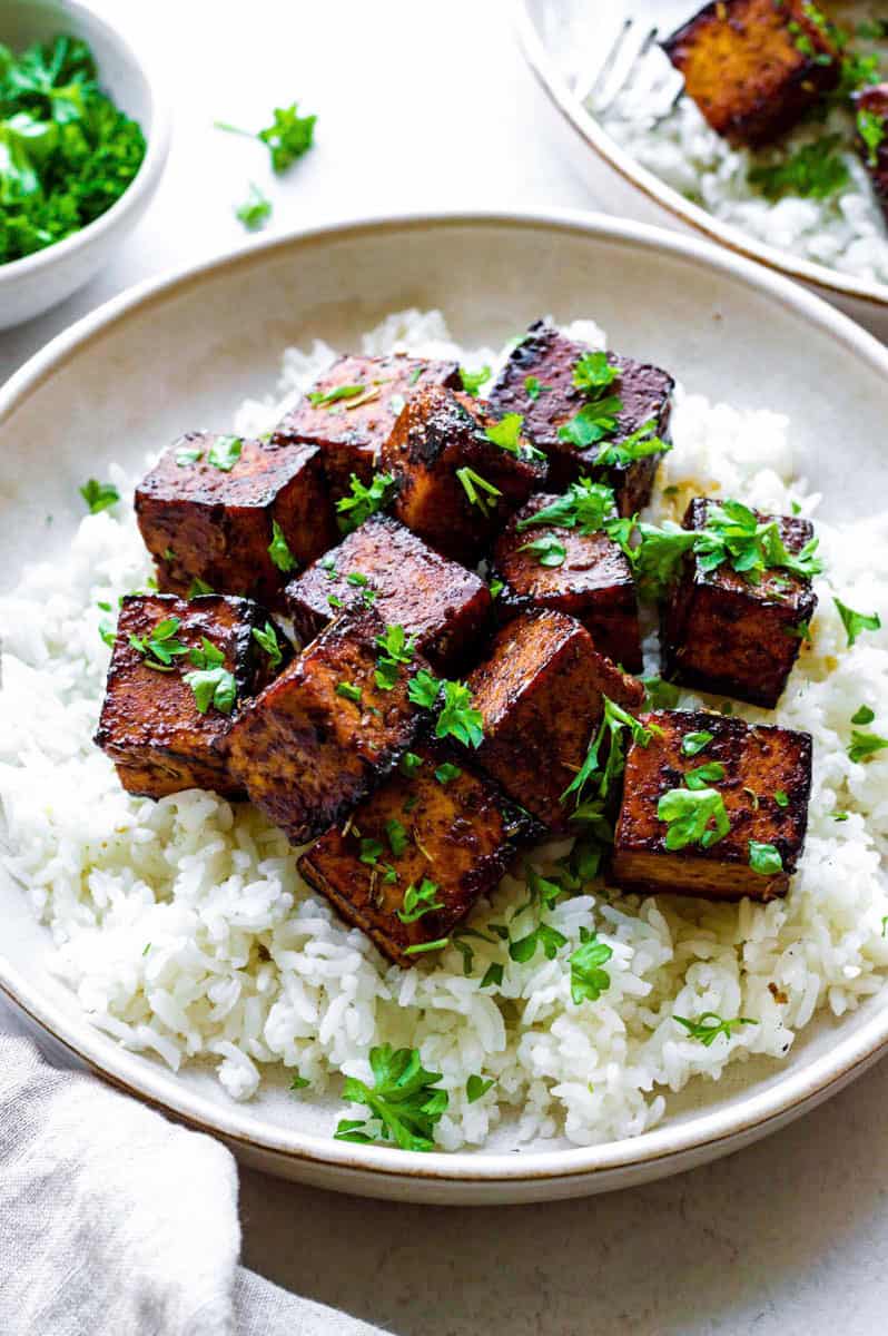 close-up front view of tofu on top of rice in a bowl.