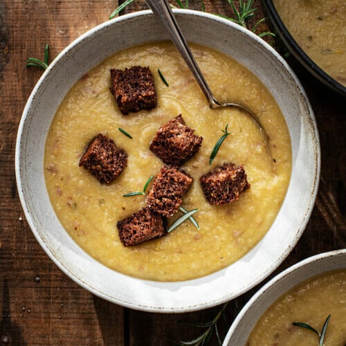 overhead of cauliflower potato souop in a bowl with croutons.