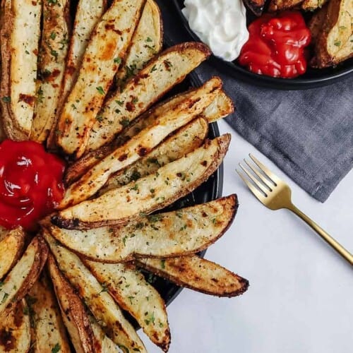 overhead of baked potato wedges on a serving dish.