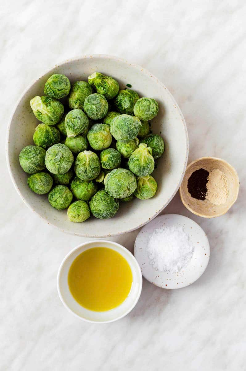 Gathered ingredients for cooking frozen brussels sprouts on the stovetop.