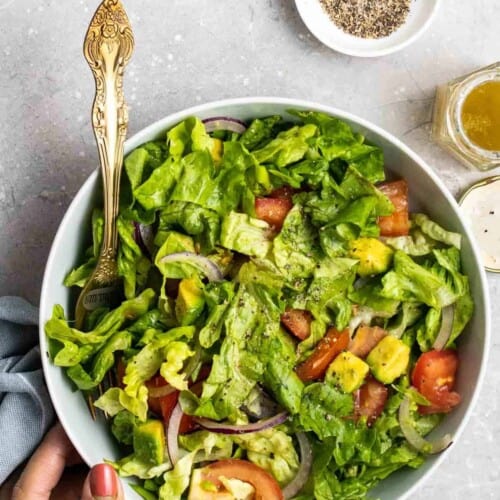 overhead of romain lettuce avocado salad in a white bowl.